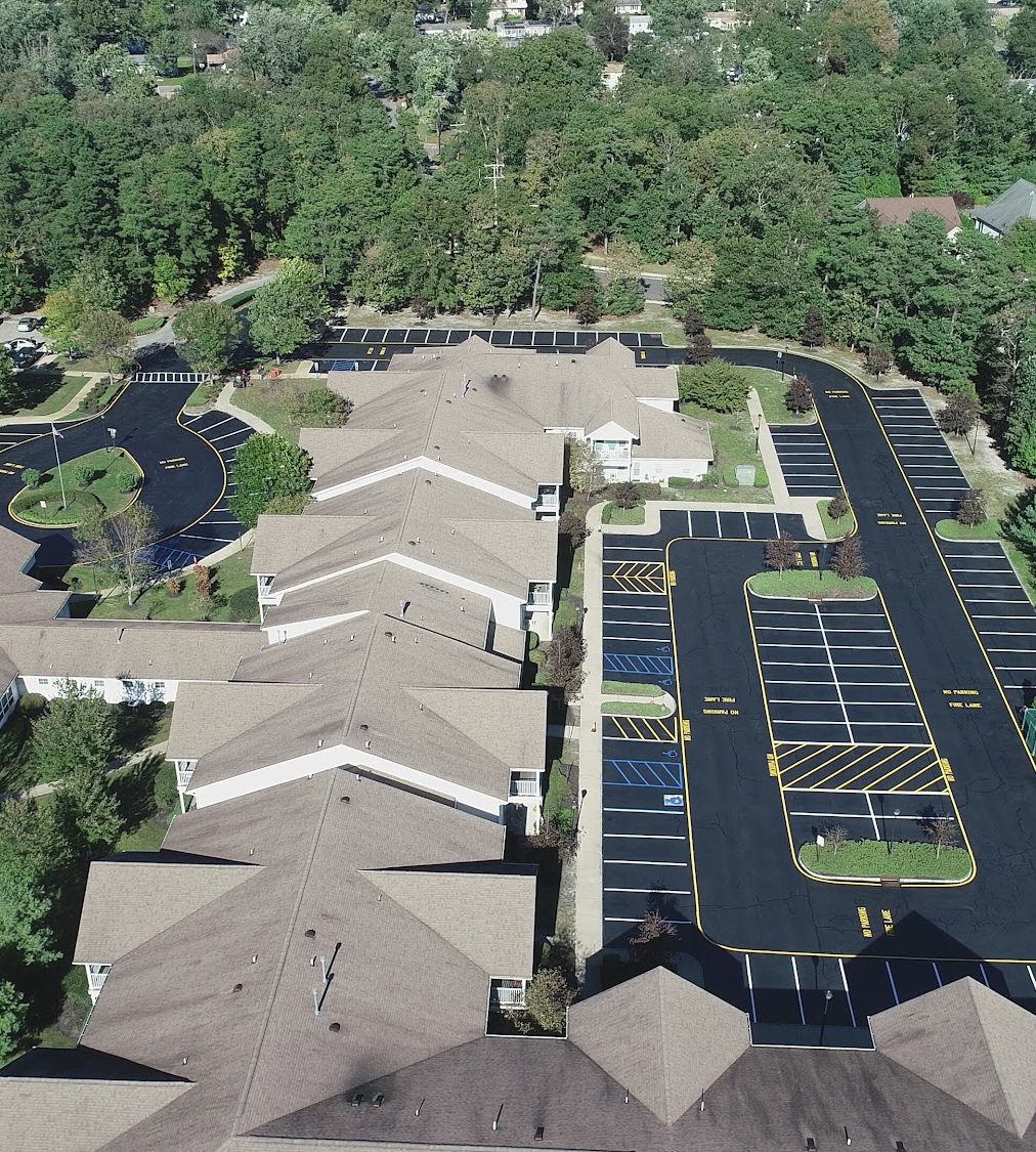 Aerial view of a townhome community with freshly paved and striped parking lots